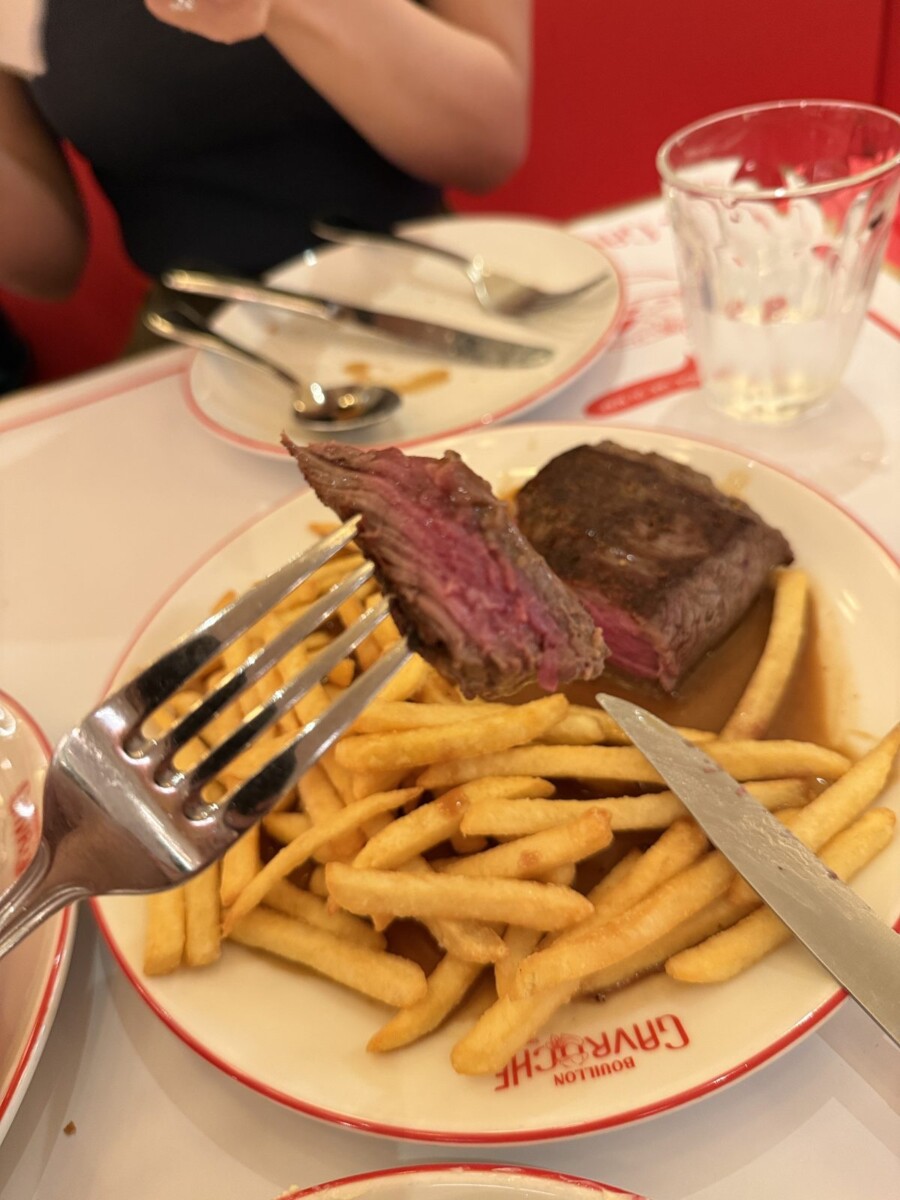 Sliced Wagyu petit tender steak showing a pink centre, with French fries