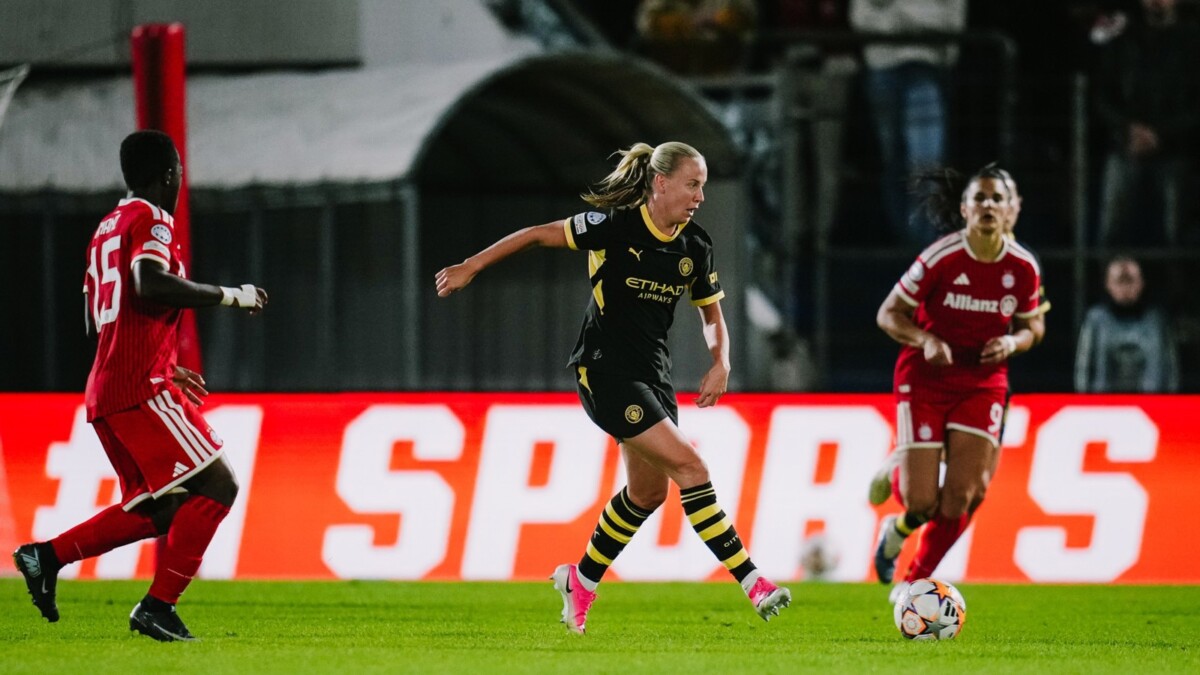 A Manchester City Women player dribbles past Bayern Munich defenders at Sportpark Unterhaching