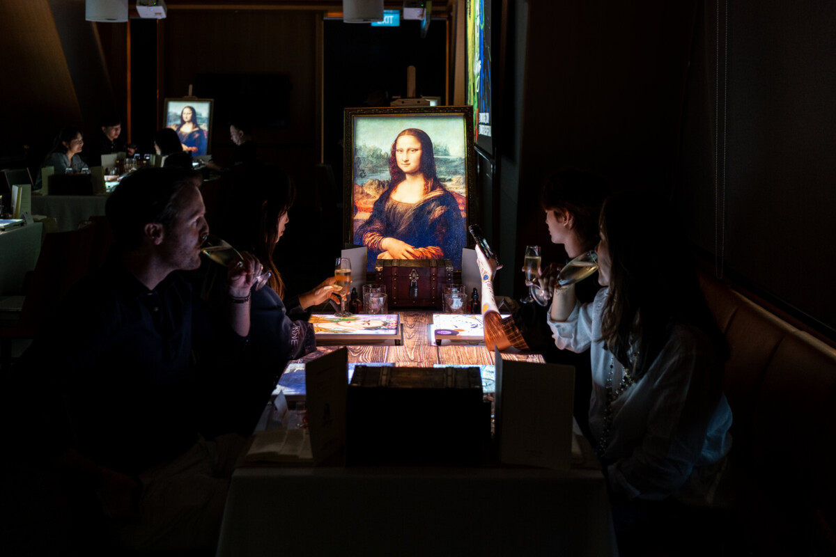 Diners at the 7 Paintings dinner show at Conrad Singapore Marina Bay with a Mona Lisa canvas on the table