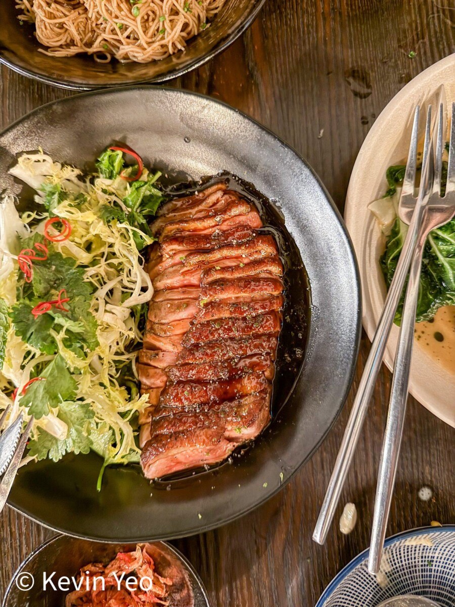 Roasted duck breast with five-spice caramel and kaffir lime over coriander frisee at 808 Eating House
