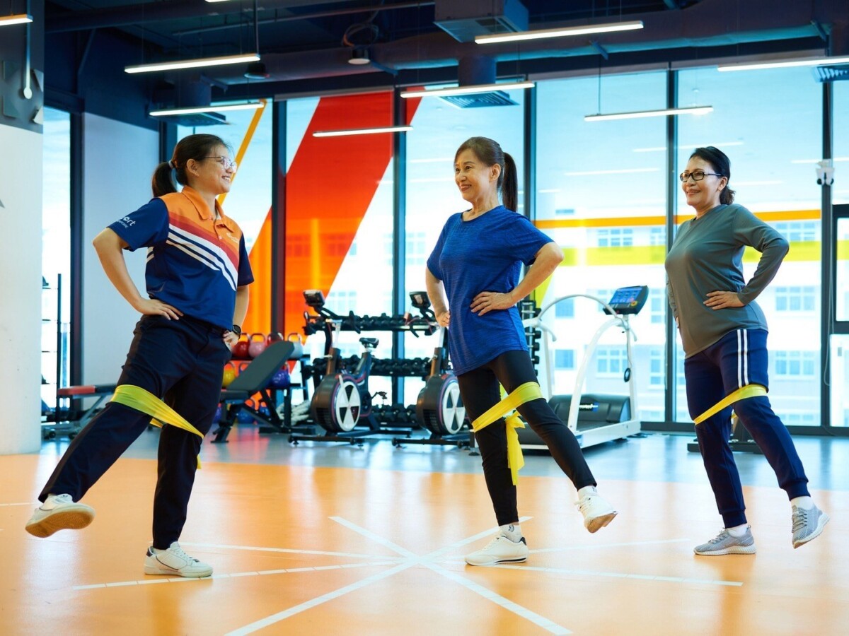 Active Health coach leads older adults through a resistance band strength exercise