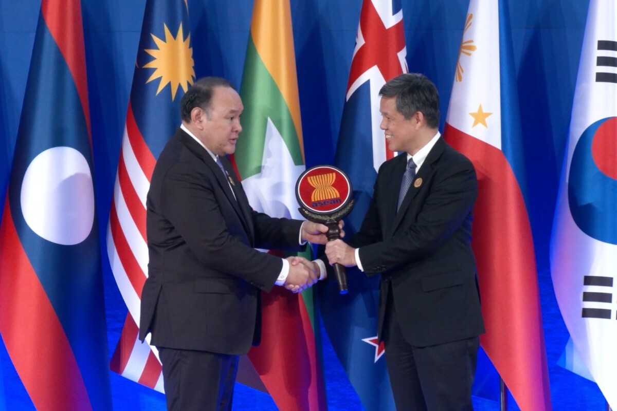 Chan Chun Sing receives the ADMM chairmanship from Philippine Defence Secretary Gilberto Teodoro in front of ASEAN flags