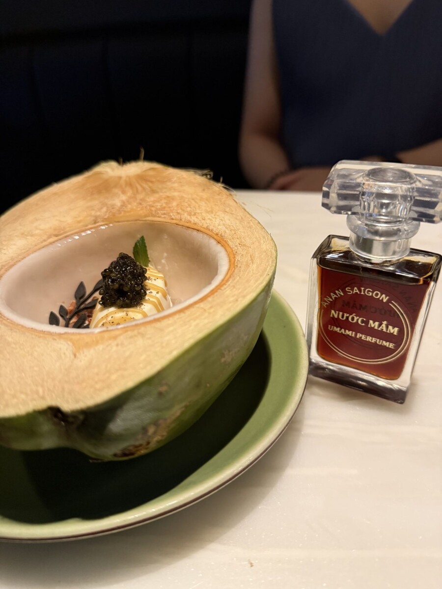 Fish sauce ice cream served in a halved young coconut with caviar and a mini Nuoc Mam Umami Perfume bottle at Anan Saigon