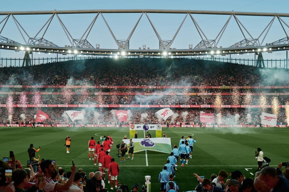 Players from Arsenal and Chelsea walk out onto the pitch at Emirates Stadium