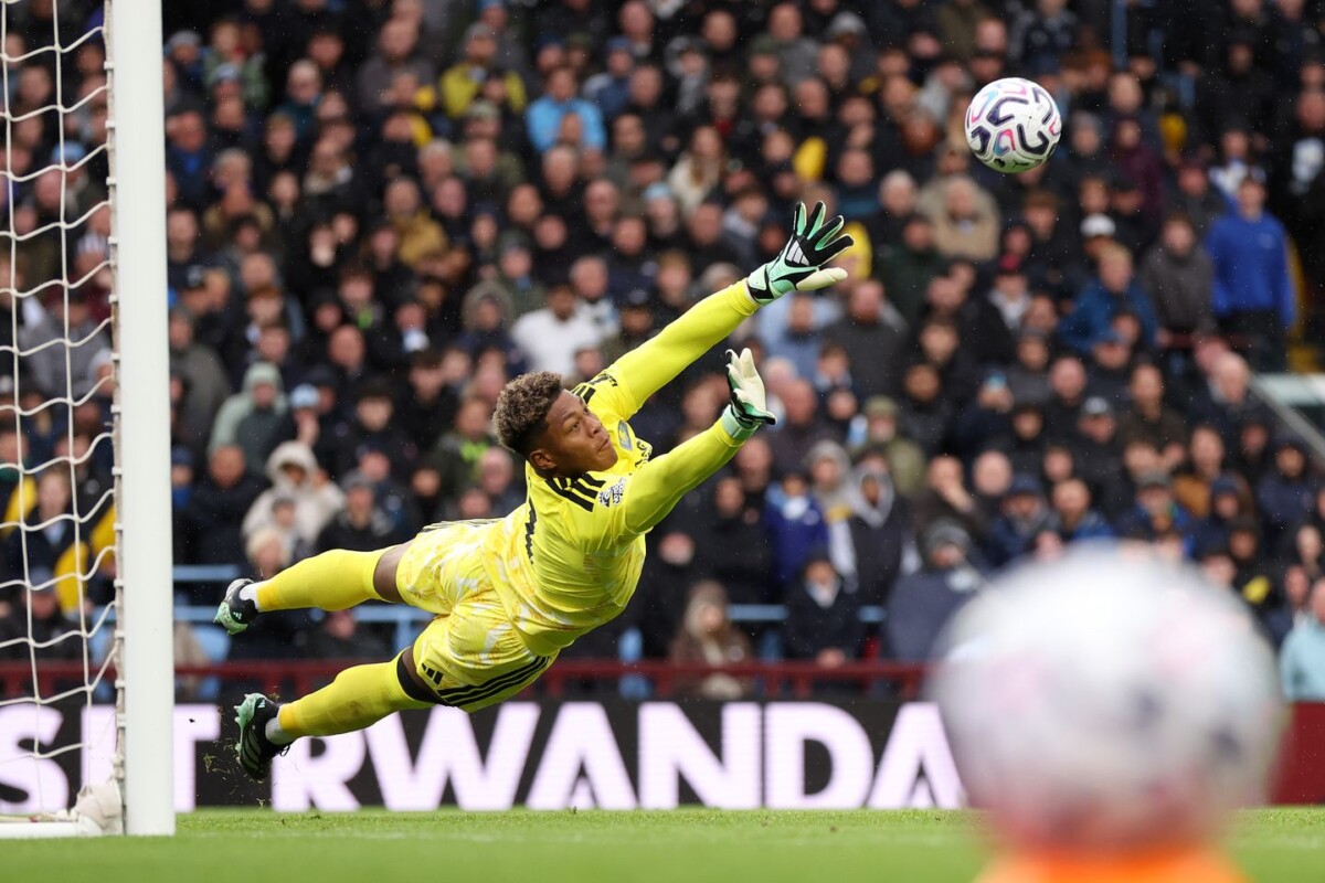 Aston Villa goalkeeper Zion Suzuki diving to make a save