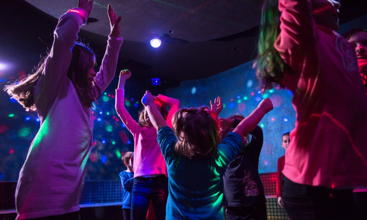 Children dancing under glow lights at a Baby Rave event