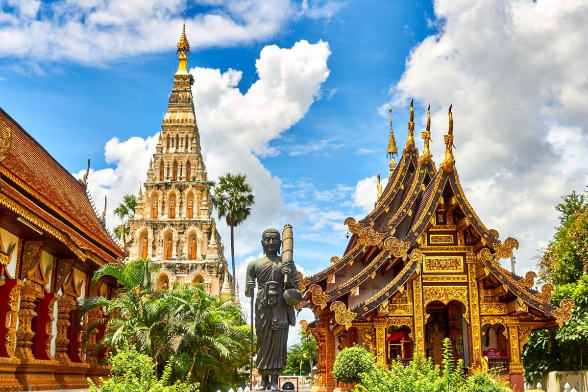 Ornate Thai temple with chedi, Buddha statue and traditional Thai roofline