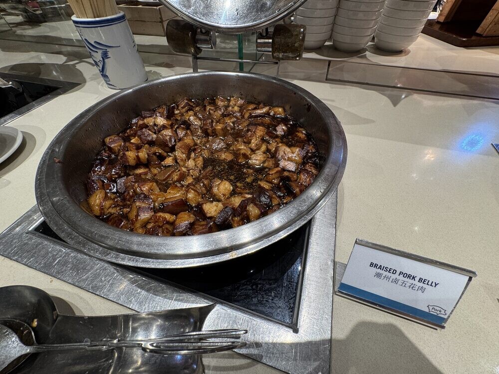 Chafing dish of Braised Pork Belly in dark sauce with a serving spoon and dish label