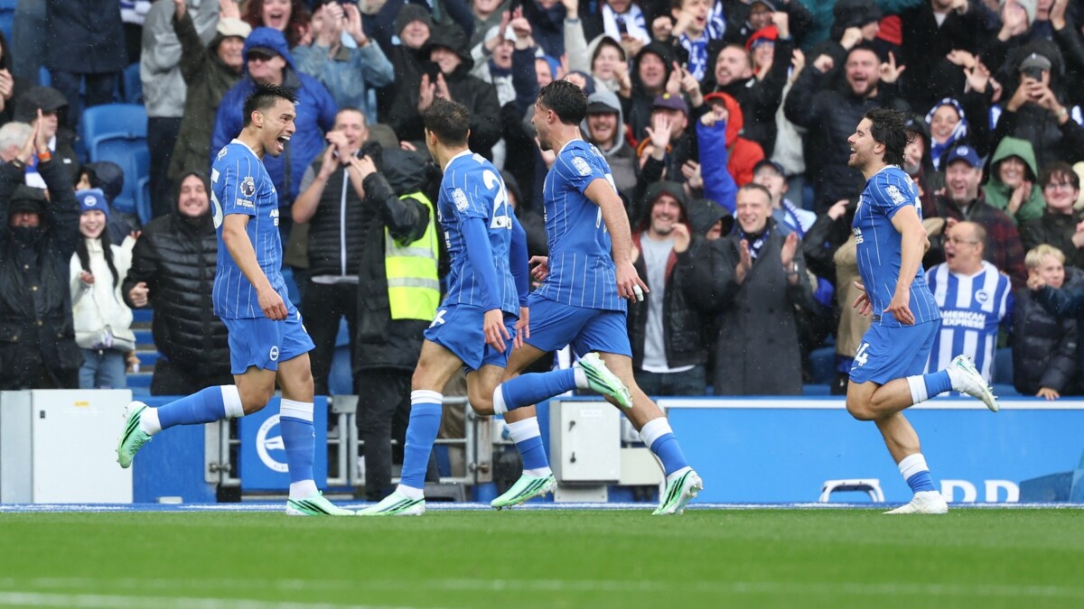 Brighton players in blue kits celebrate together in front of the Amex crowd