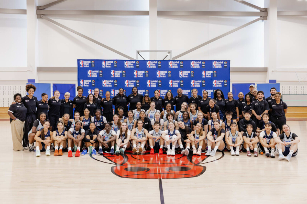 Basketball Without Borders campers and coaches in a group photo on an indoor court