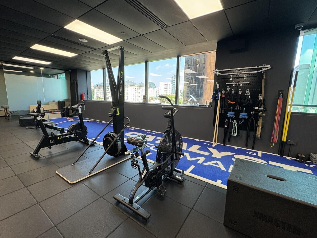 Catalyst Performance cardio zone with air bikes and rowing machines overlooking Singapore CBD skyline
