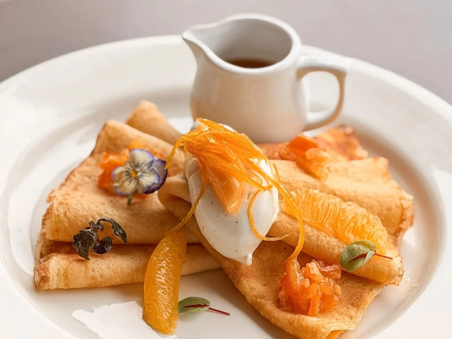 Swedish pancakes with orange segments, mascarpone and a jug of saffron orange sauce