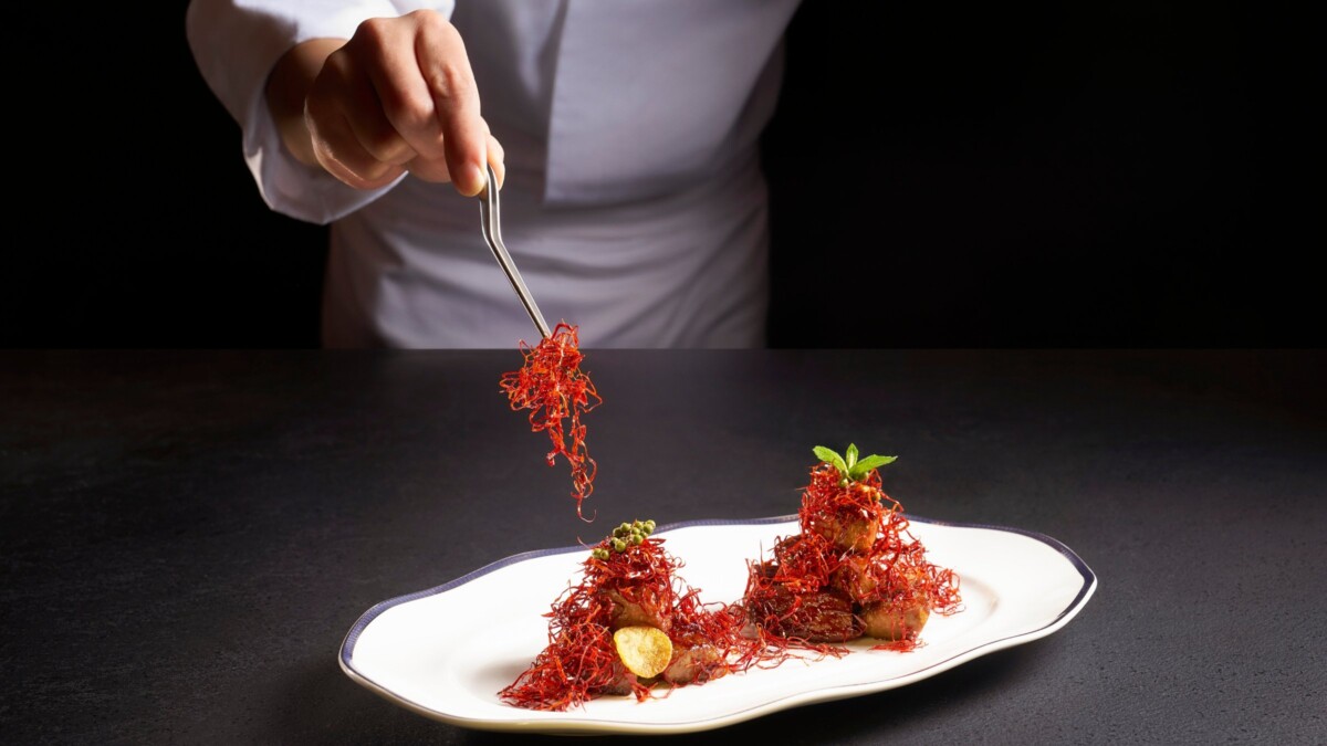 Chef plating diced Wagyu beef with Sichuan peppercorn at Cherry Garden