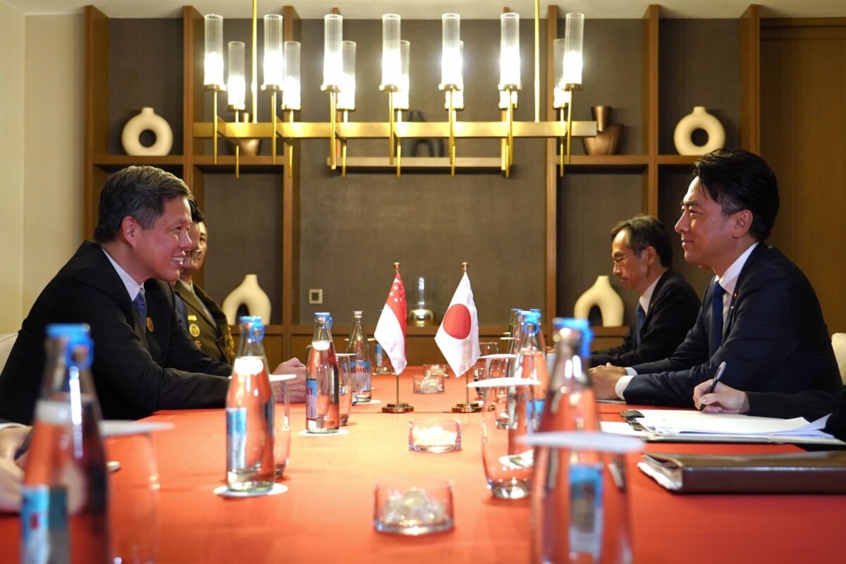 Chan Chun Sing in a bilateral meeting with the Japanese delegation, with Singapore and Japan flags on the table