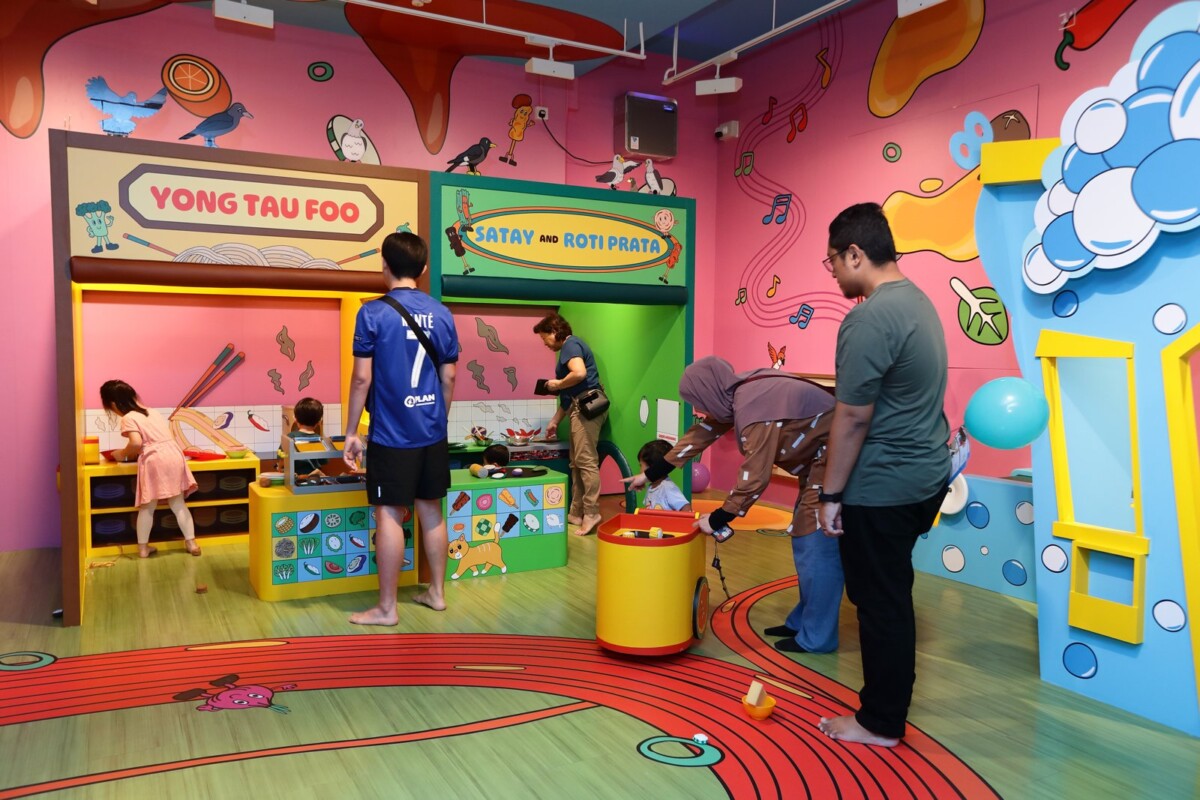 Children and parents playing at pretend yong tau foo and satay and roti prata stalls in Into the Hawkerverse at Children's Museum Singapore