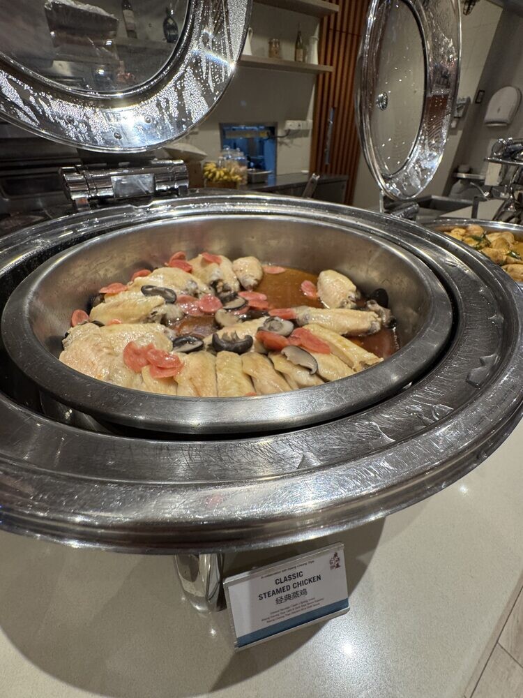 Chafing dish of Classic Steamed Chicken pieces with mushrooms, with a printed dish label in front
