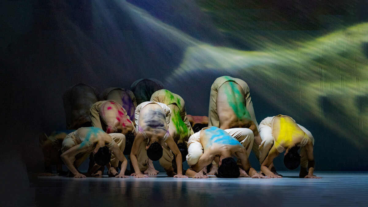 Cloud Gate dancers bowed low on stage under projected light in Sounding Light