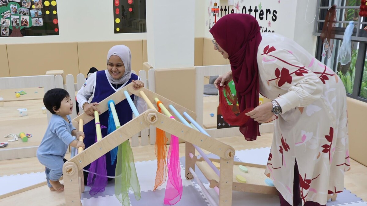 Infant caregivers with a toddler in a Singapore infant care centre