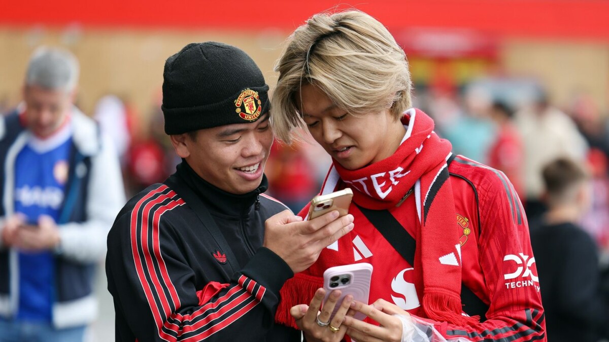 Premier League fans checking phones