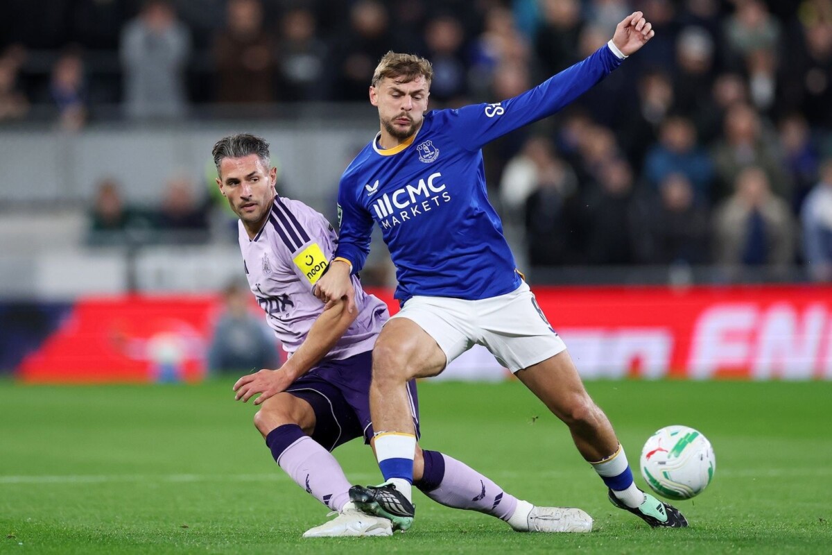 Everton player in blue goes into a challenge with a Newcastle player during the Carabao Cup last-16 tie