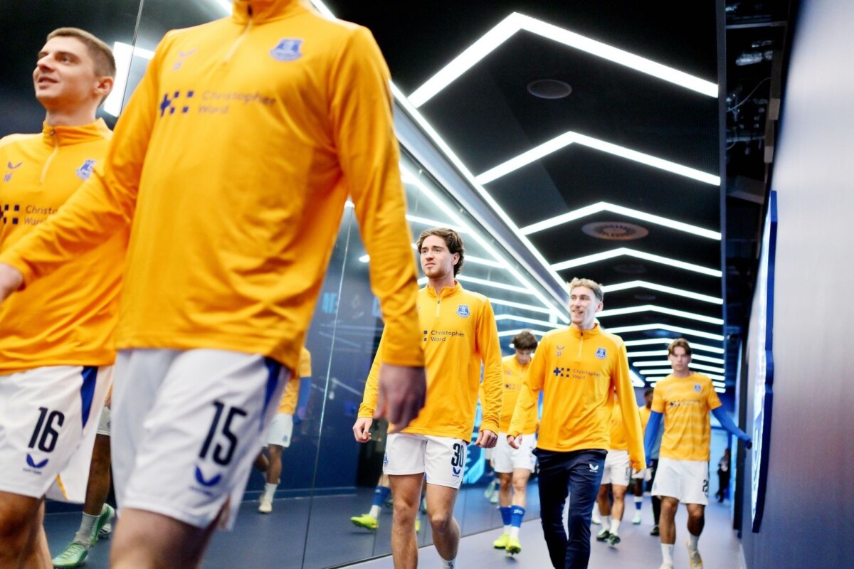Everton players in yellow training tops walk out of the tunnel at Hill Dickinson Stadium