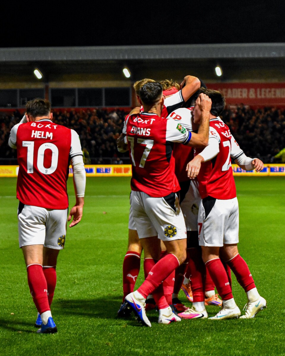Fleetwood Town players huddle to celebrate the opening goal against Arsenal at Highbury Stadium
