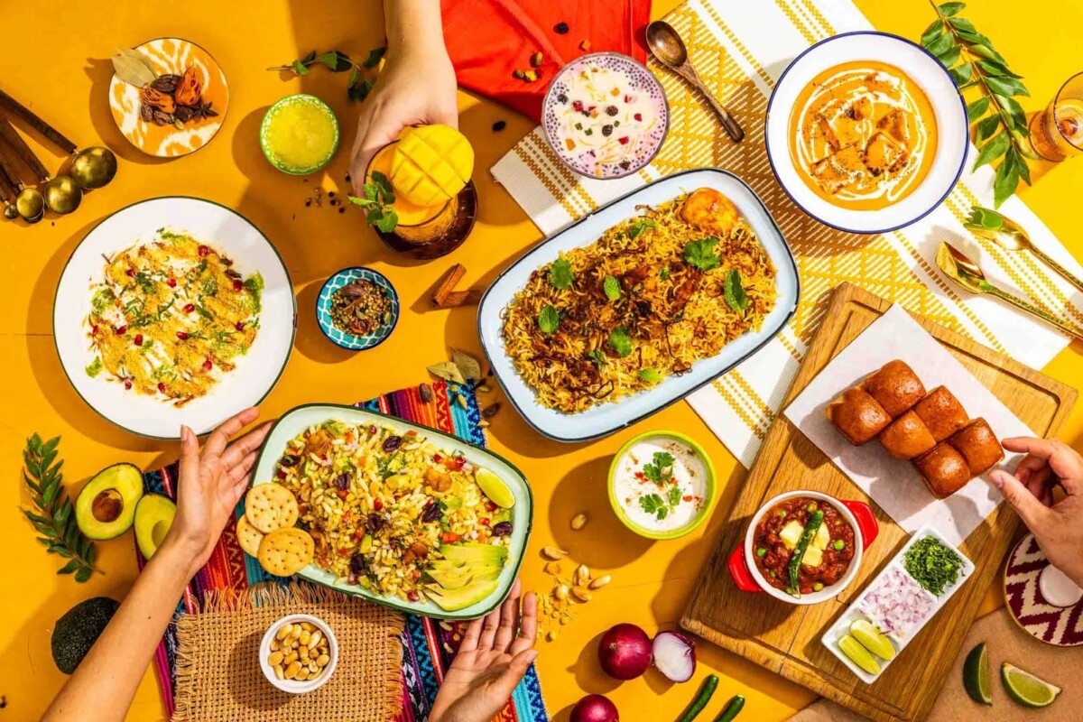 Indian dishes including biryani, curries and chutneys spread across a table at Gully
