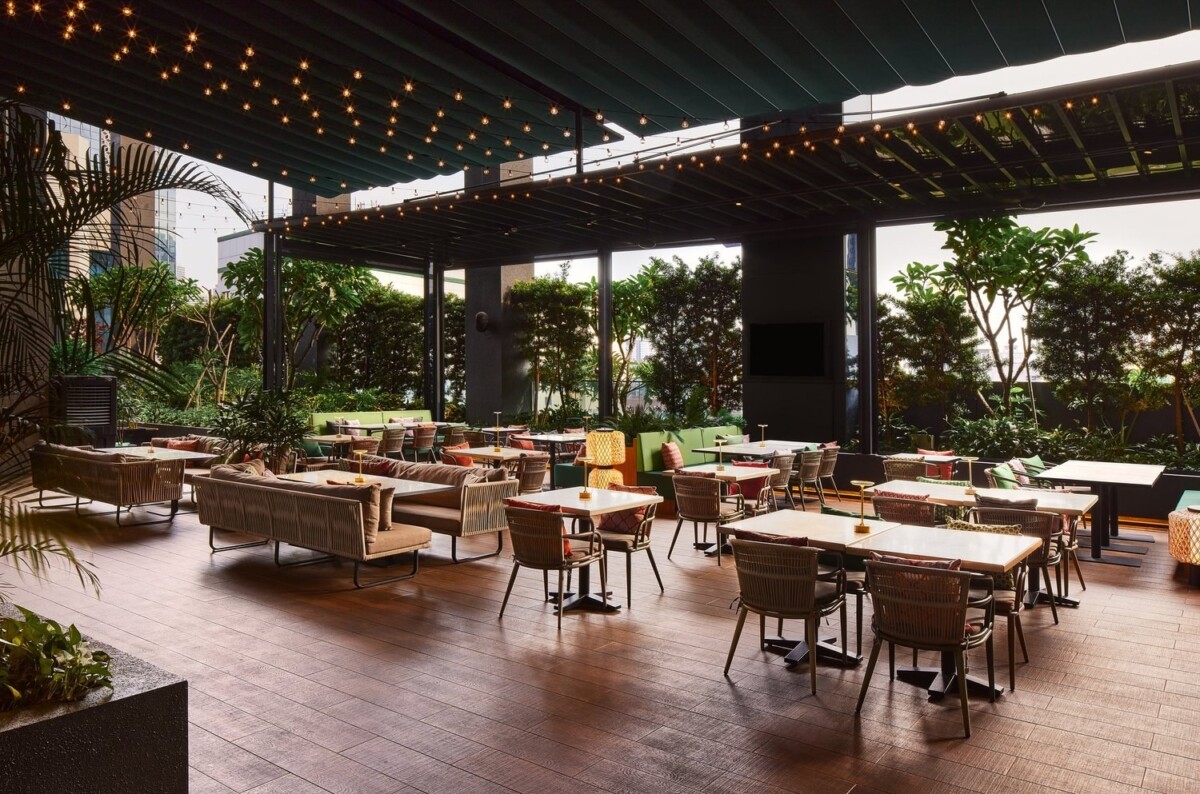 Outdoor patio seating at Gully with string lights and greenery