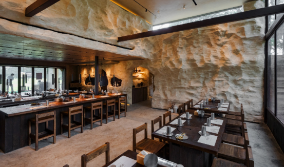 GOCHU cave-inspired dining interior with stone walls and wooden beams