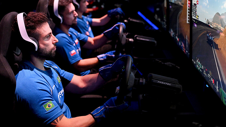 Gran Turismo World Series drivers racing on simulators at a live event