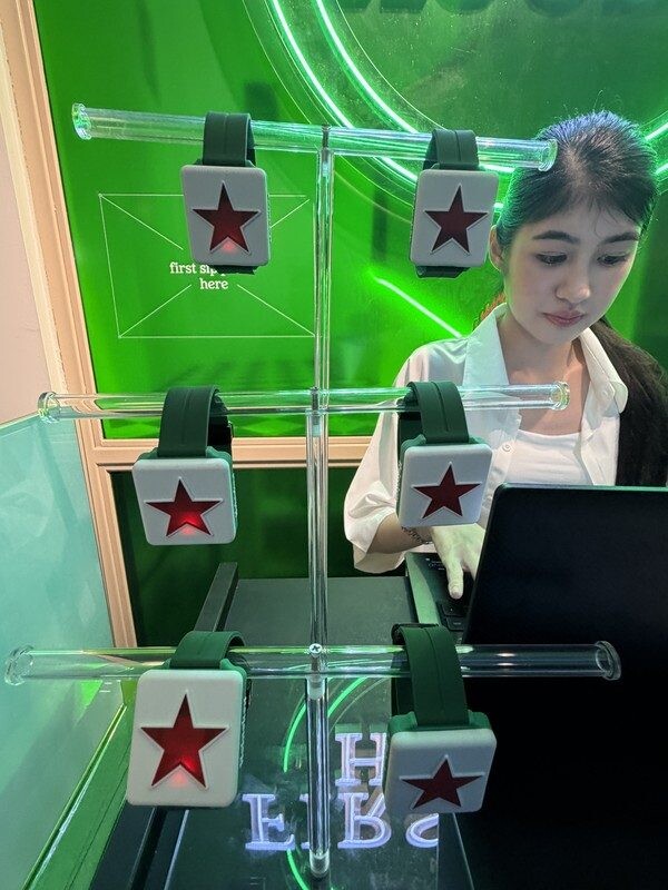 Heineken Star Tap bracelets with star buckles displayed on glass tubes at First Sip House