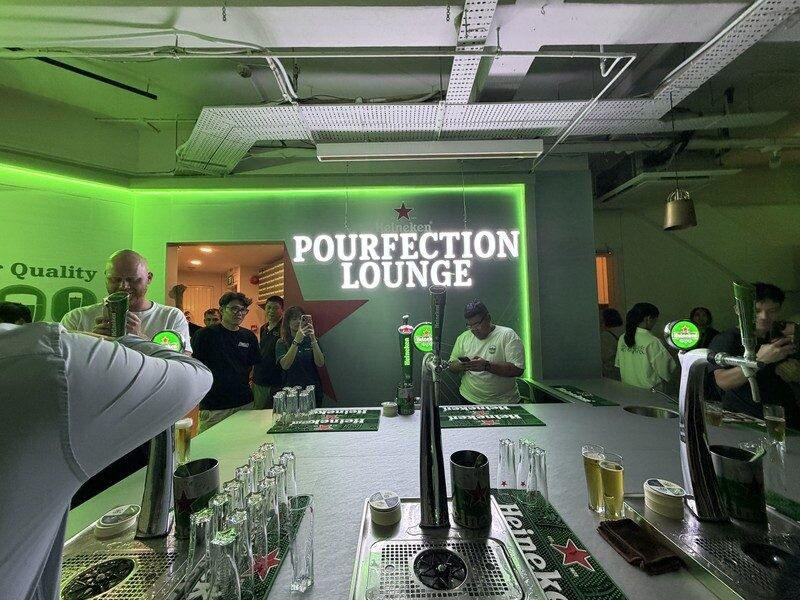 Pourfection Lounge signage with bartenders and beer taps at Heineken First Sip House