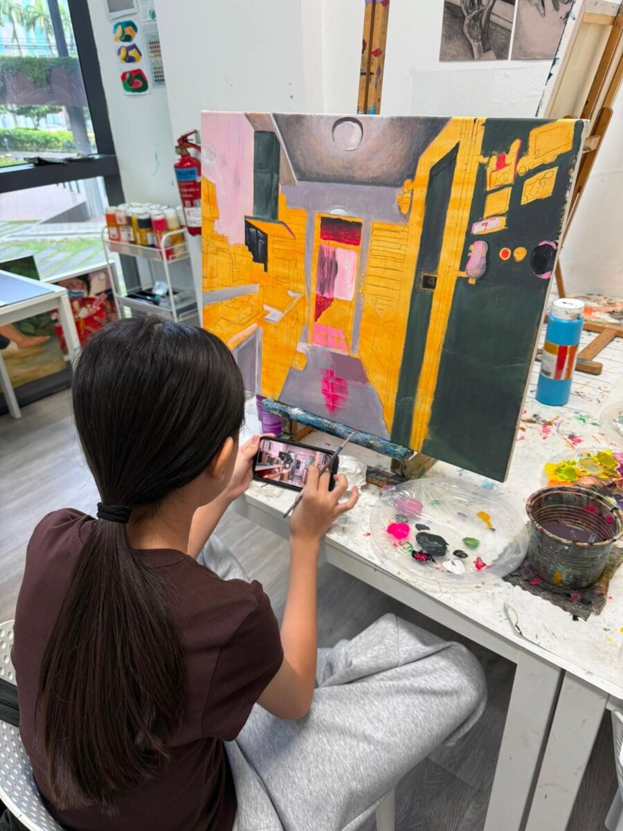 Young artist painting at Artgrain studio ahead of the HOME exhibition
