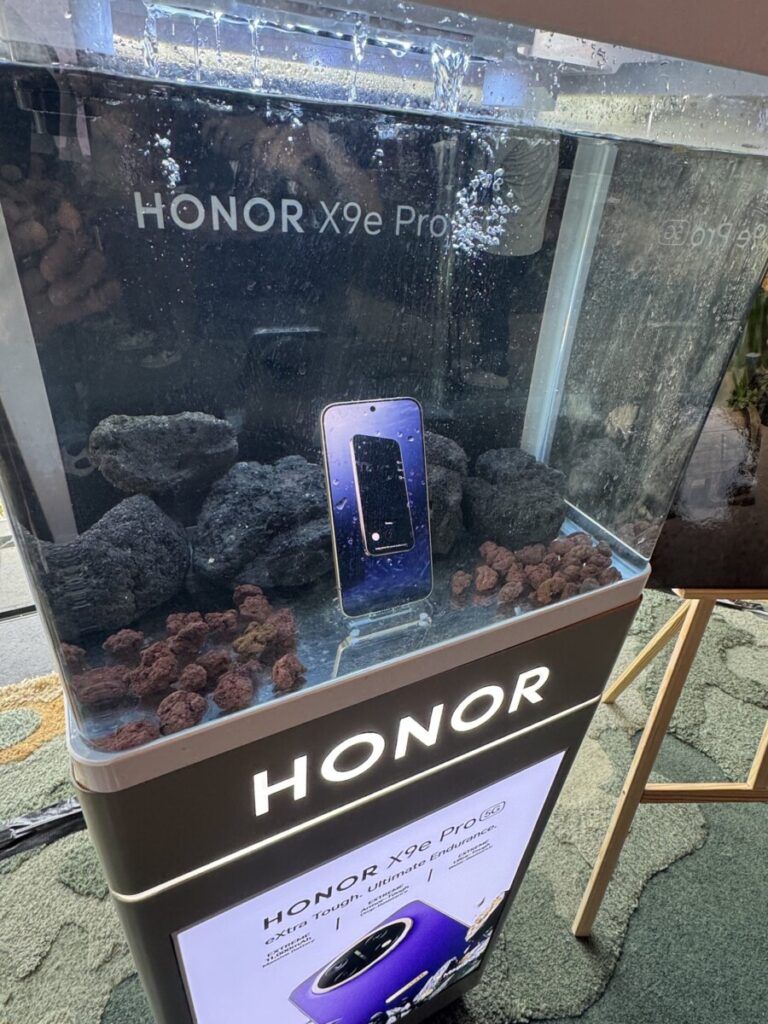 HONOR X9e Pro with its screen on inside a water tank demo at the Singapore launch