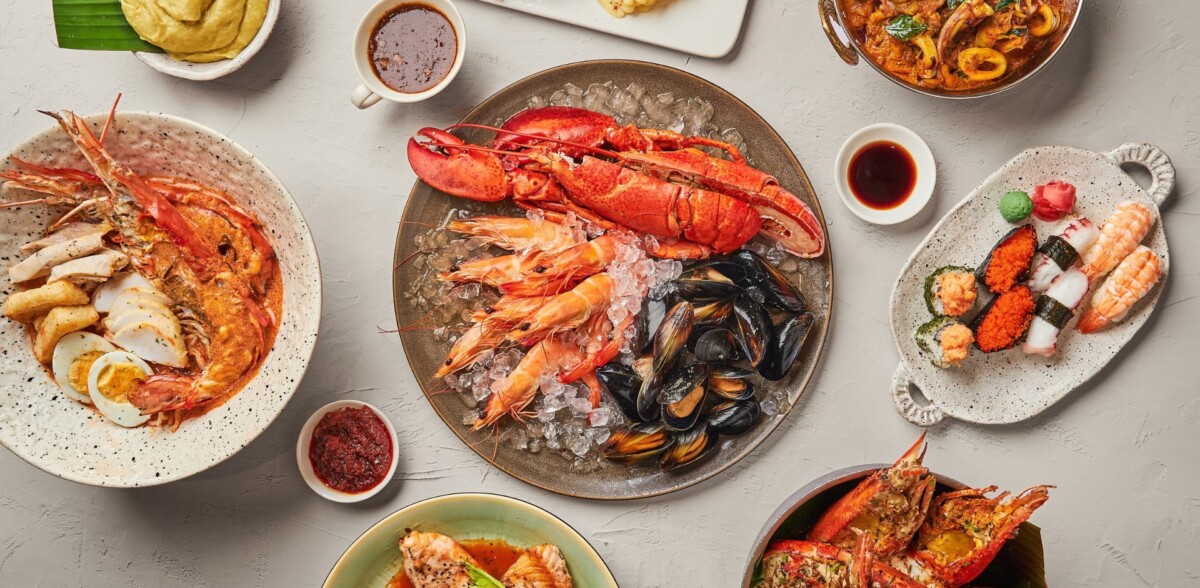 J65 buffet spread with Boston lobster, prawns, mussels, laksa and sushi on a grey table