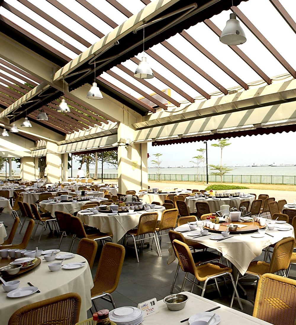 JUMBO Seafood East Coast dining room with round tables under awnings facing the sea