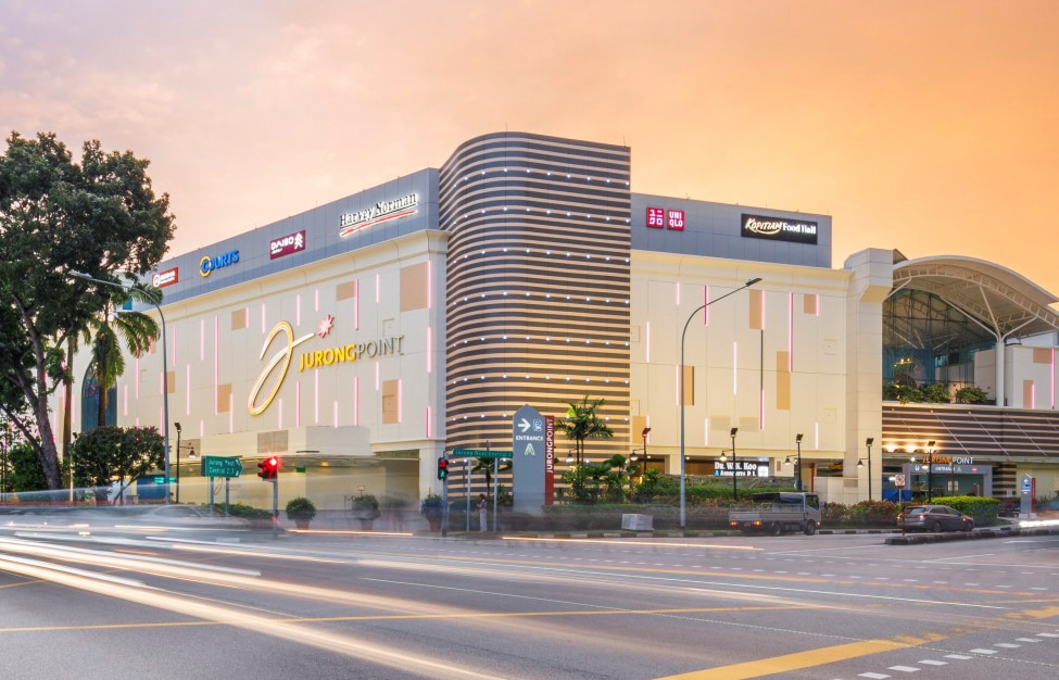 Jurong Point shopping centre exterior at dusk with traffic on Jurong West Central 2