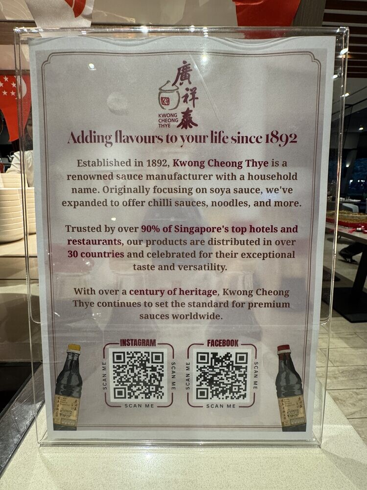 Kwong Cheong Thye standee at the buffet reading Adding flavours to your life since 1892, with QR codes below the text