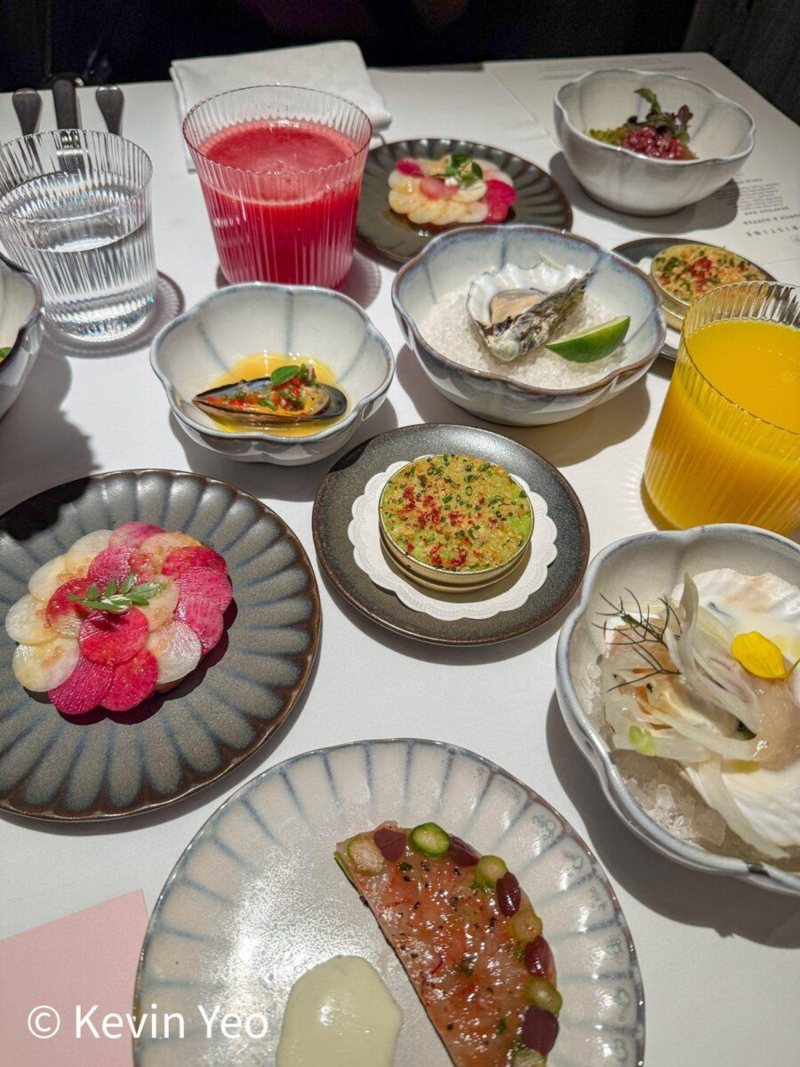 Spread of cold appetisers from the self-serve section at Le Pristine Singapore including oysters tartare and fresh juices