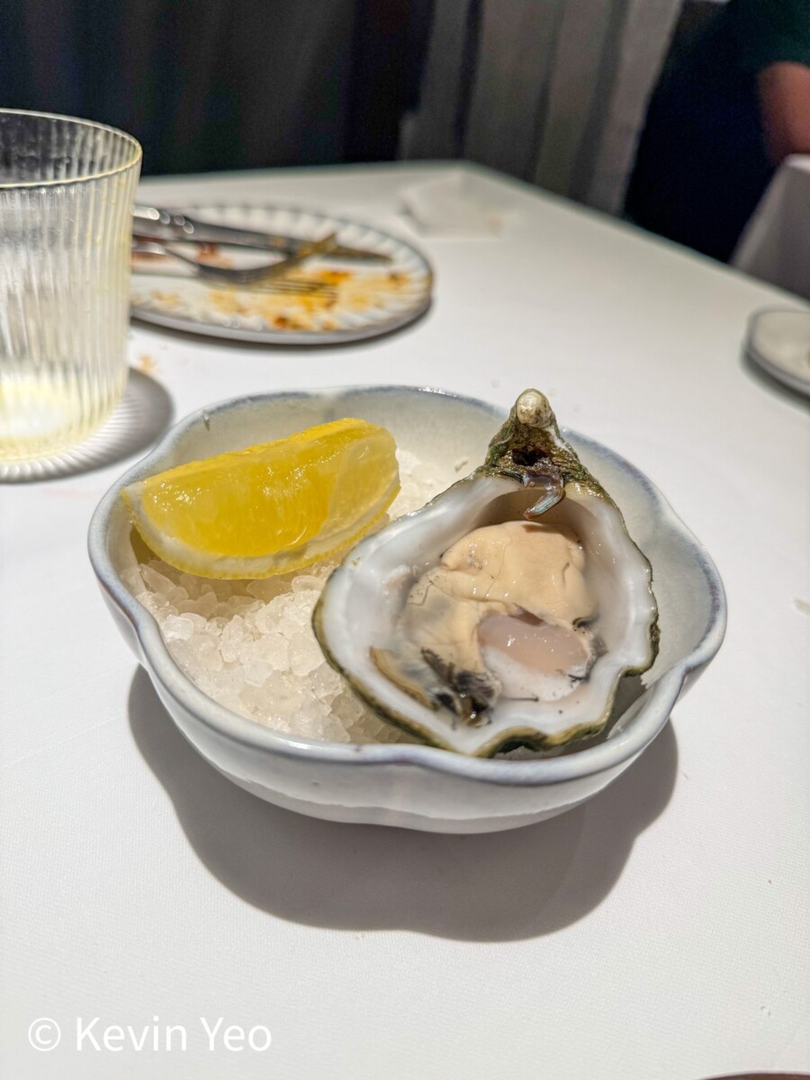 Irish Mor oyster at Le Pristine Singapore served on crushed ice with a lemon wedge