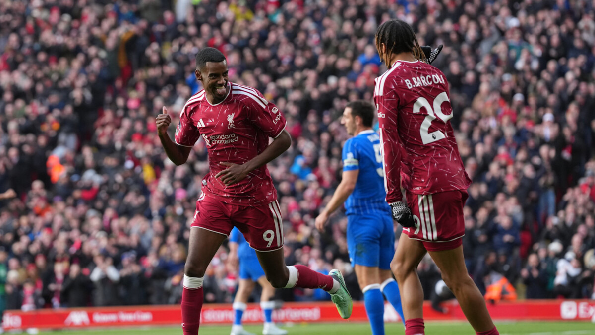 Liverpool players celebrate in front of a Brighton player at Anfield