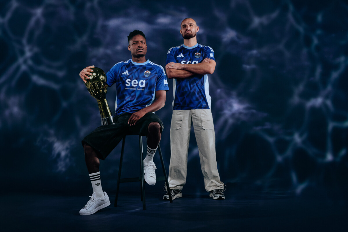 Two Lion City Sailors players in oceanic blue 2026/27 away kit with SPL trophy