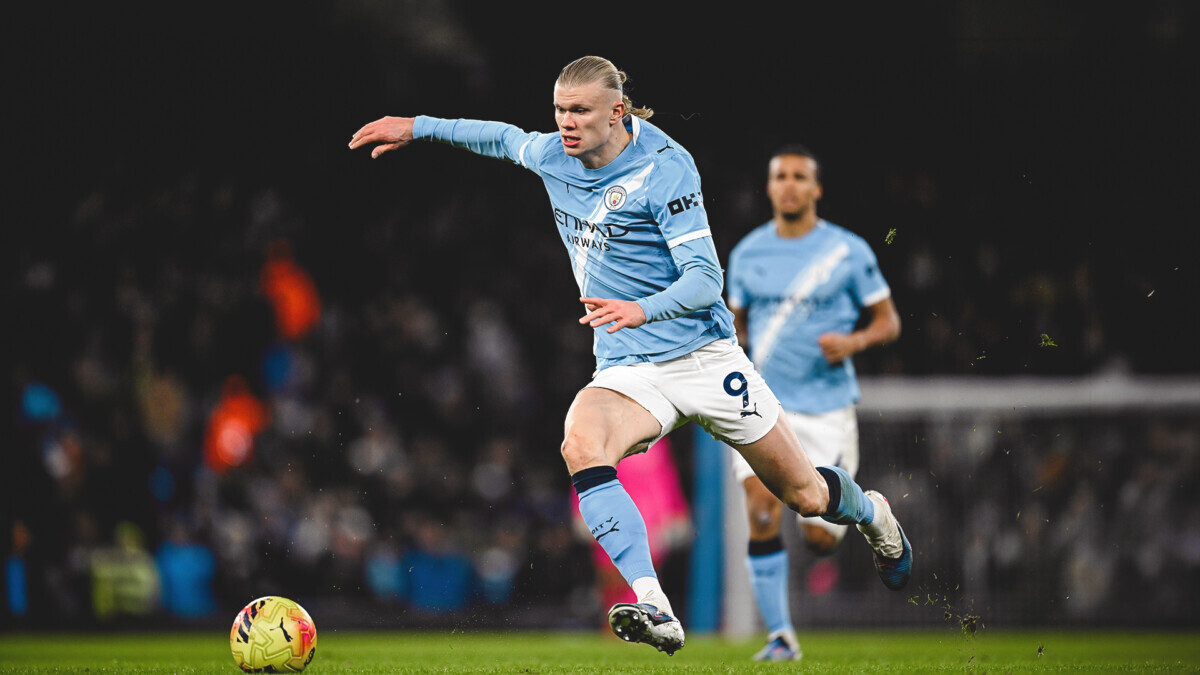Erling Haaland in a Manchester City shirt celebrating at the Etihad Stadium