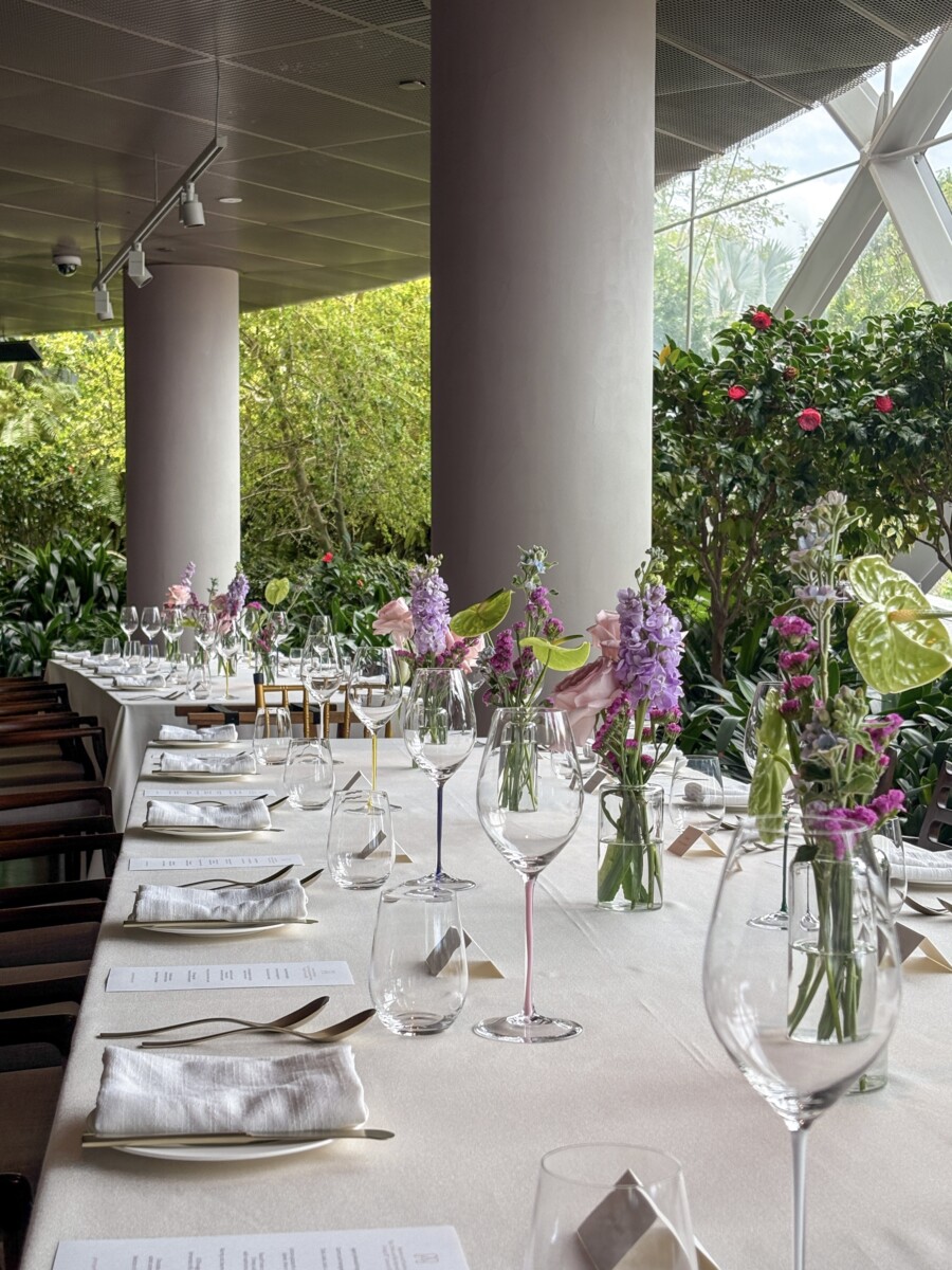 Marguerite dining room set up with purple and pink floral centrepieces for an event