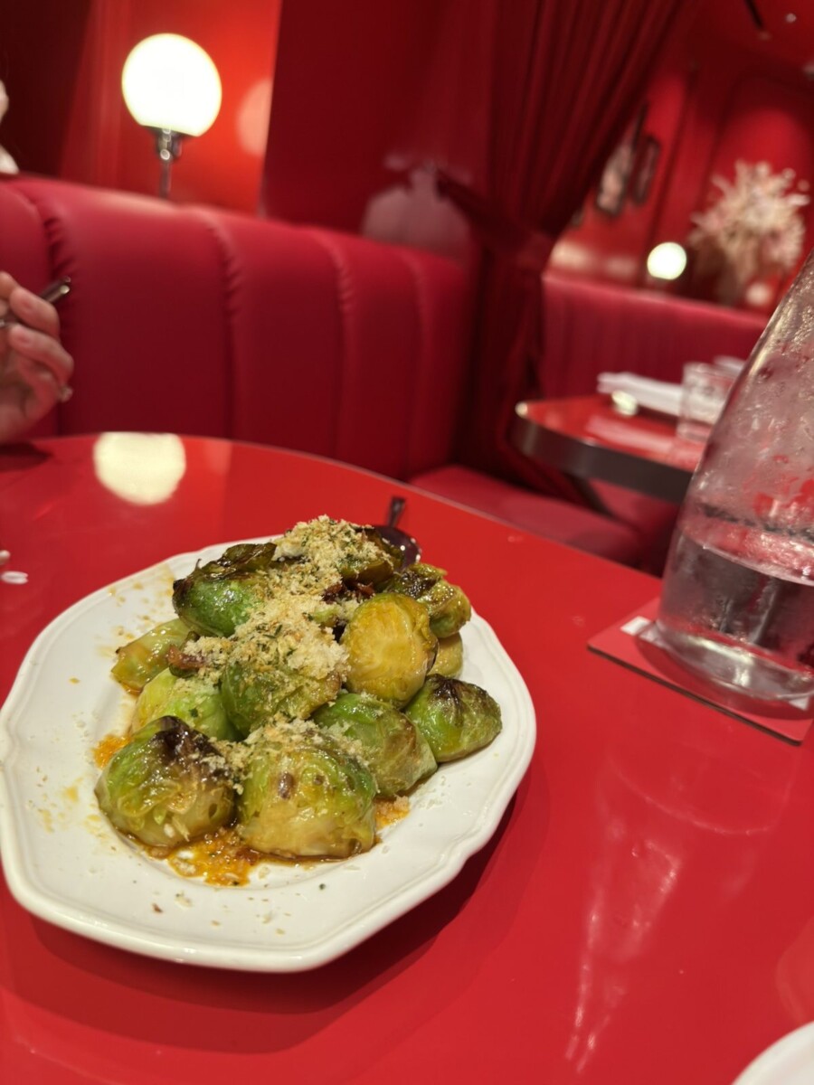 Brussels sprouts with herbed breadcrumbs, parmigiano and chilli oil on a white plate
