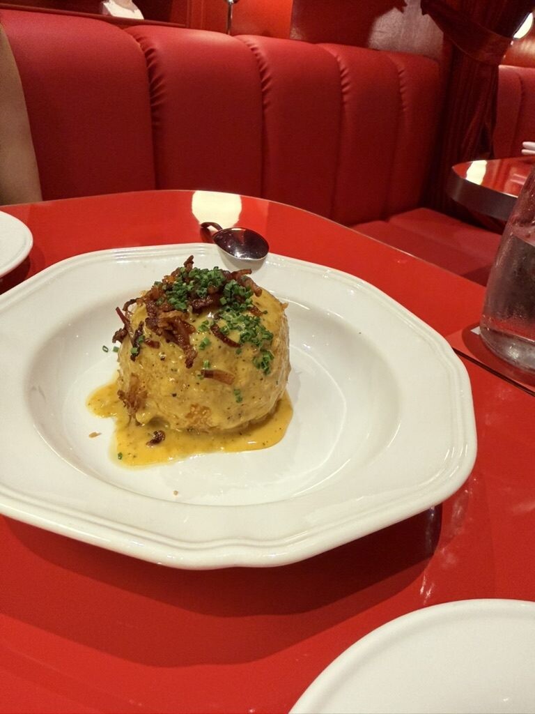 Fried burrata dome topped with guanciale and chives in carbonara cream