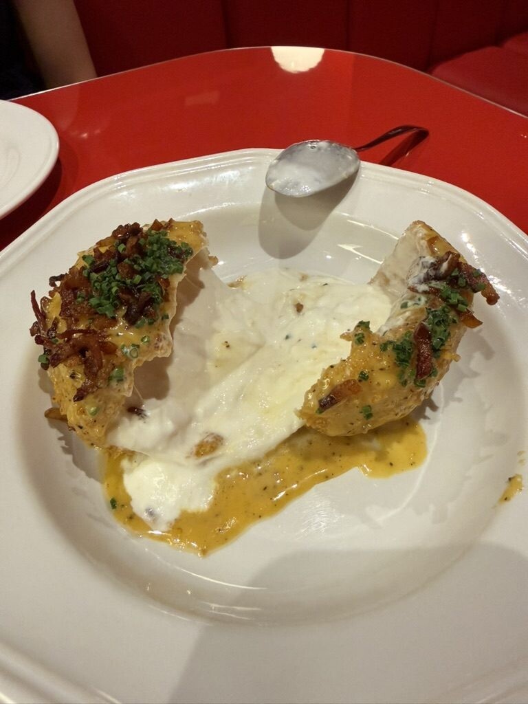 Fried burrata cut open with molten white cheese flooding onto the plate