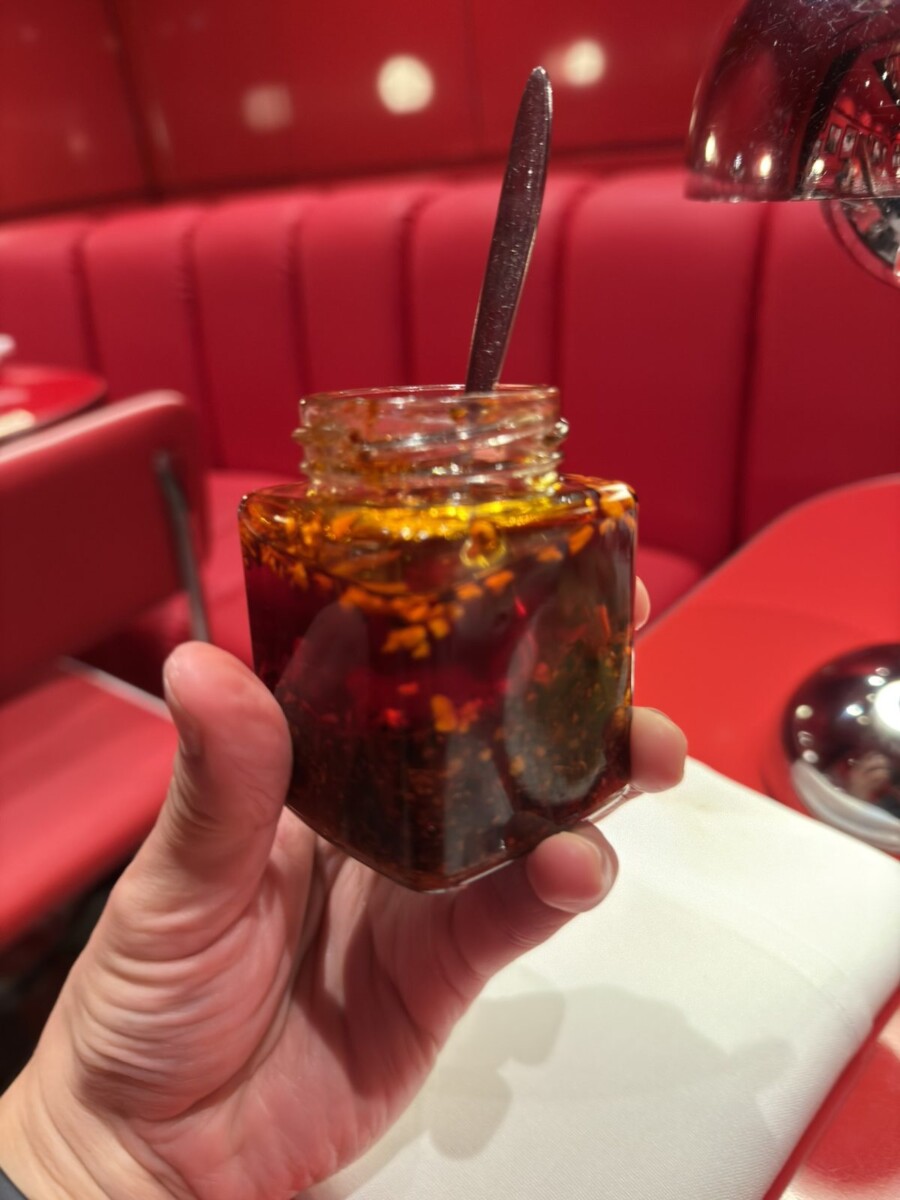 Jar of house made chilli with dark red oil and crunchy bits