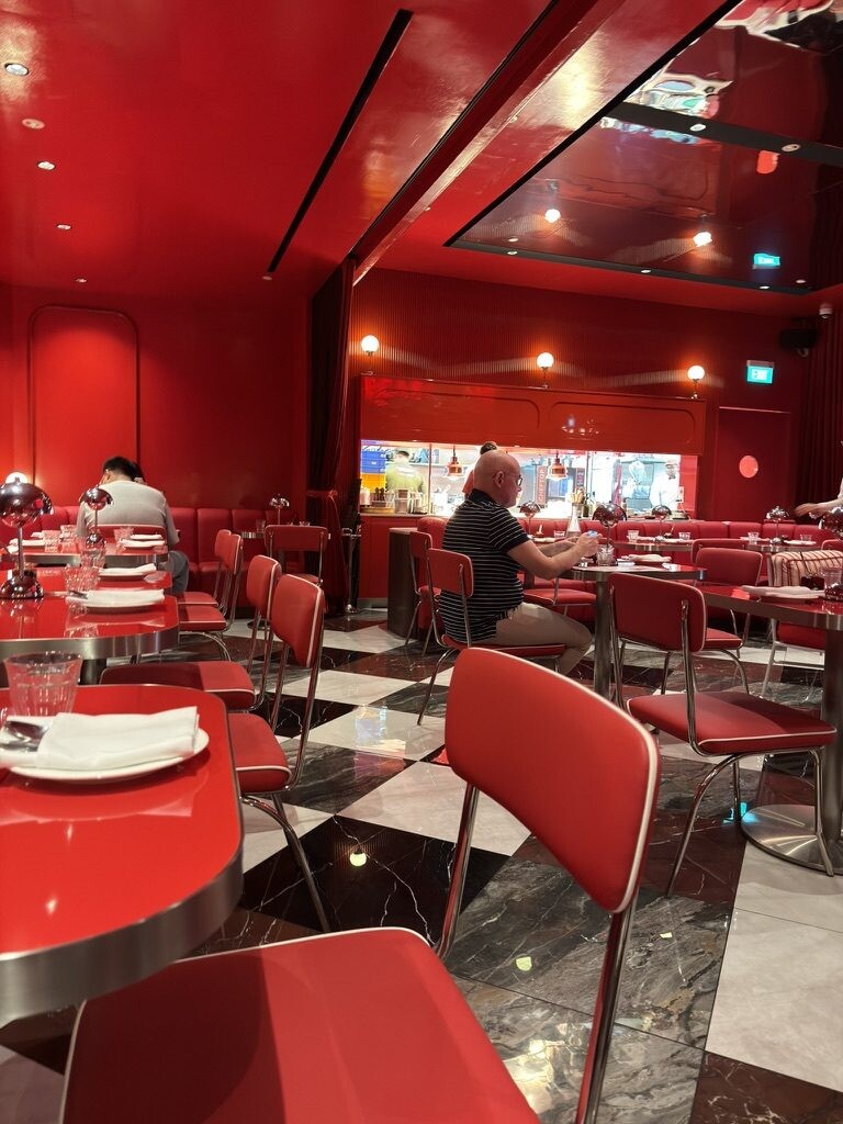 Red dining room at Medusa with a checkerboard marble floor and banquettes