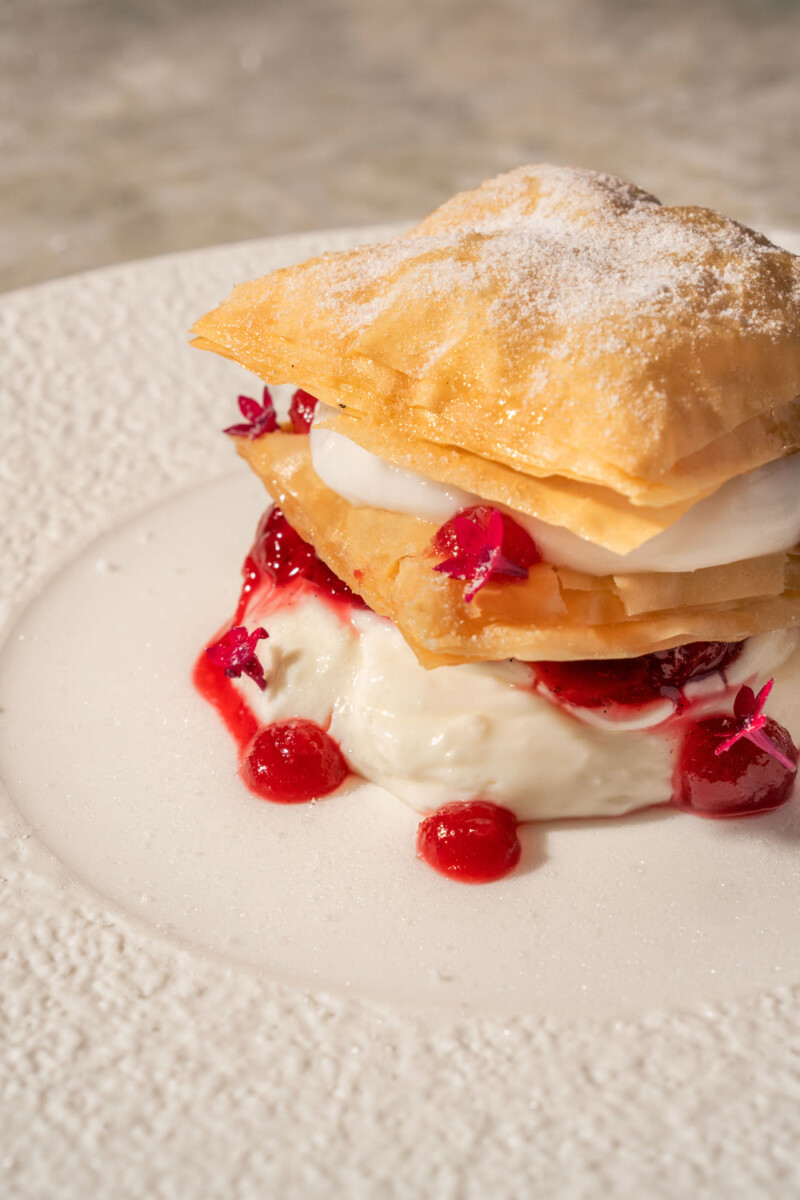 Muhallabia milk pudding with red fruit sauce and crisp pastry layers at Petra